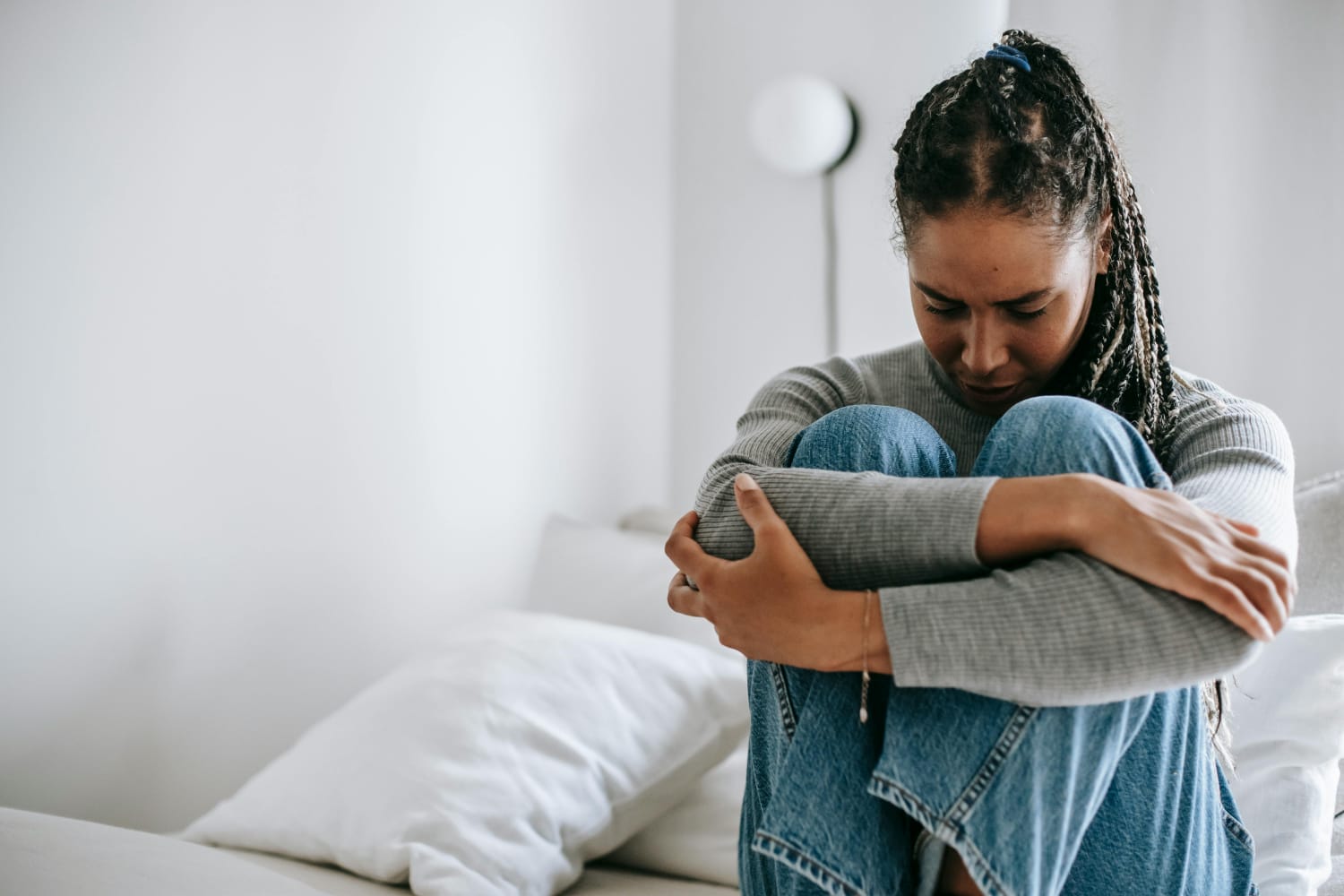 A woman sitting with her head down, symbolizing breaking negative thought patterns through CBT therapy at BrightMind Wellness in Harrisburg and Philadelphia.